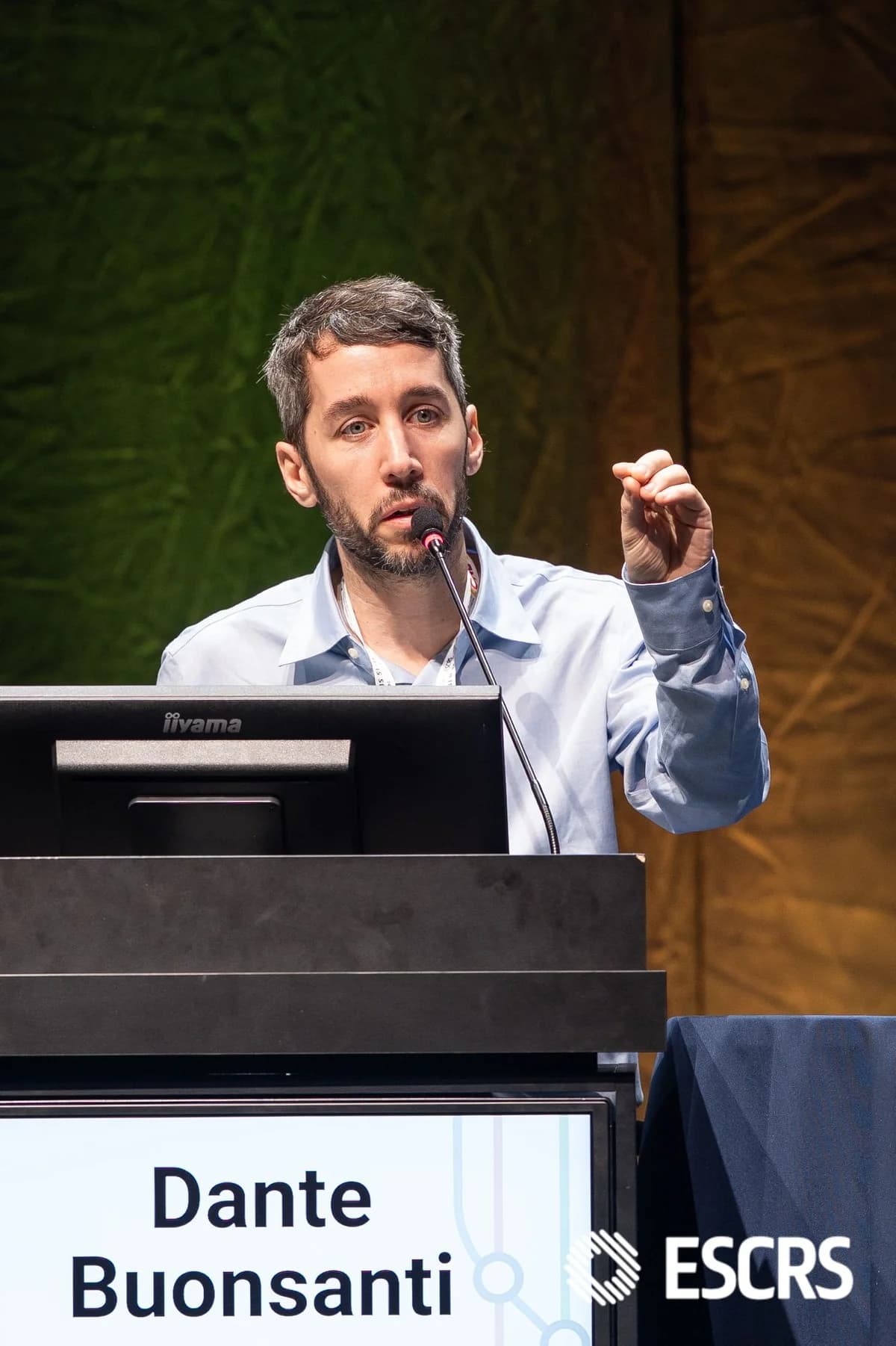Dr. Dante Buonsanti durante una conferencia de ESCRS, con su nombre y el logo del congreso visibles